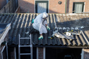 Professional asbestos removal, men in protective suits are removing asbestos